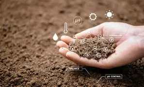Hand holding rich soil with scientific icons representing soil health analysis.